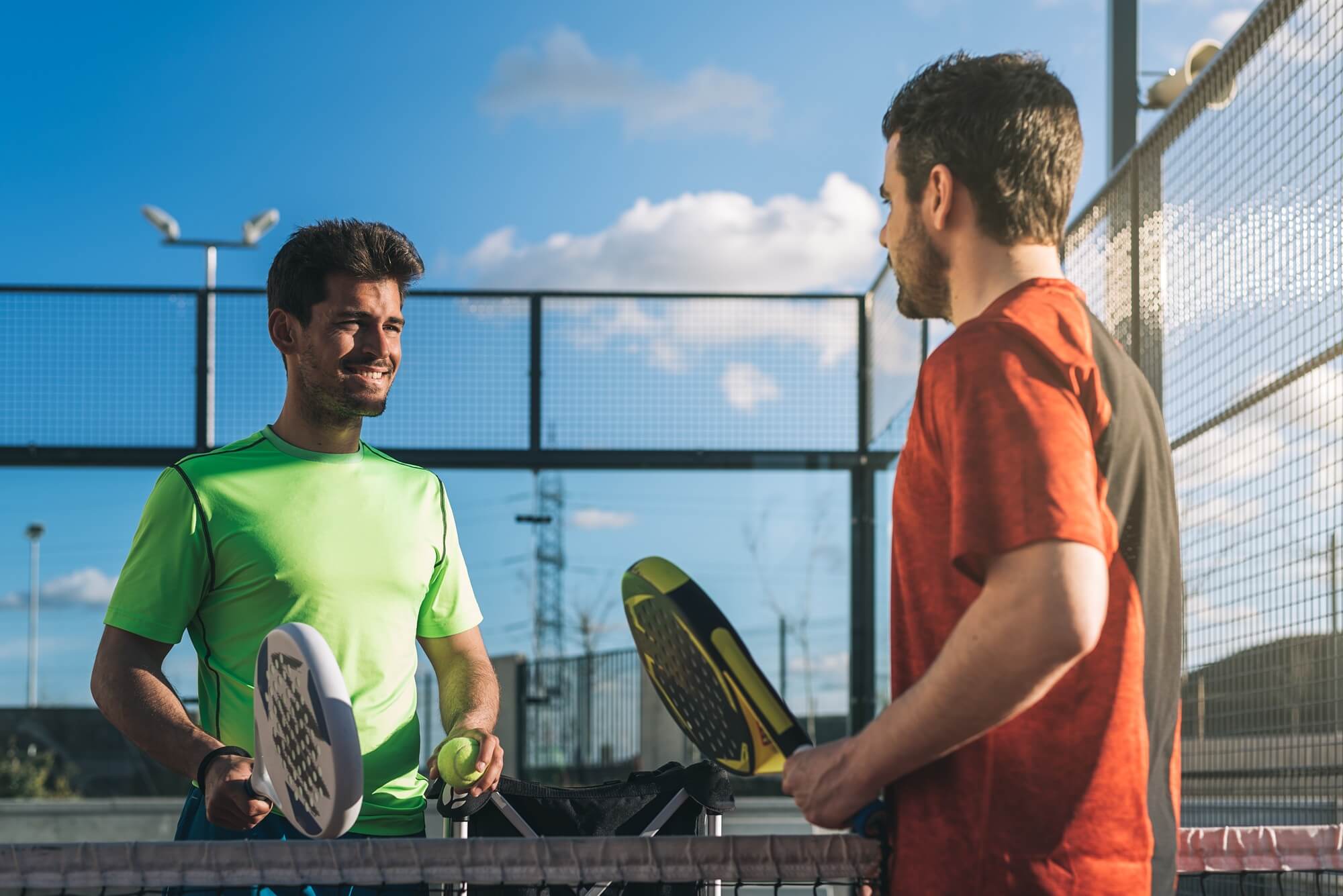 Two padel players talking beside the court